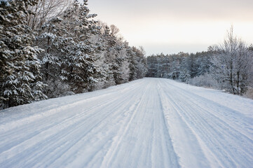 Snowy landscape, rural road in a forest. Snow all over. Winter snow cover the landscape.