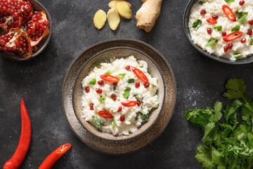 Curd rice with pomegranate, spicy, ginger on dark gray background. Top view. Indian cuisine.