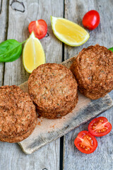 Home made  pork meatballs with  fresh cherry tomatoes on wooden rustic background. Deep fried minced  meat patties on cutting board.