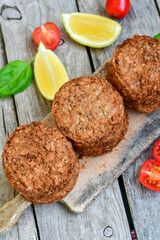 Home made  pork meatballs with  fresh cherry tomatoes on wooden rustic background. Deep fried minced  meat patties on cutting board.