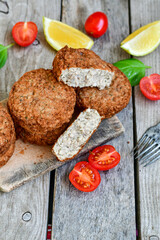 Home made  pork meatballs with  fresh cherry tomatoes on wooden rustic background. Deep fried minced  meat patties on cutting board.