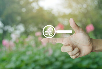 seo flat icon on finger over blur pink flower and tree in park, Technology search engine optimization concept