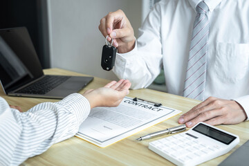 Salesman agent sending a key to customer after the good deal agreement, successful car loan insurance contract buying or selling new vehicle