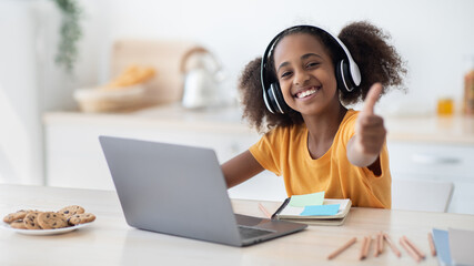 Positive african american teen girl enjoying home schooling