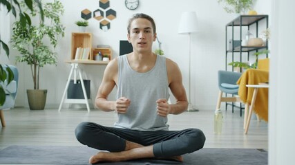 Portrait of yoga vlogger greeting followers with namaste then teaching asana recording tutorial at home. Vlogging and sports concept.