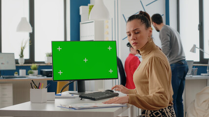 Person working with green screen on computer in business office. Woman looking at chroma key...