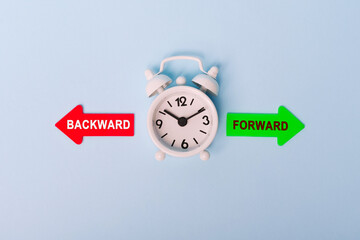 Forward vs backward. Red arrow and green arrow- direction indicator - choice of Forward or backward. Concept of choice. Two Arrows and clock on blue background, top view