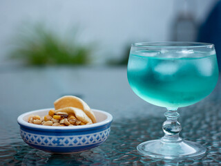 Blue gin and tonic with aperitifs in a glass cup with dew