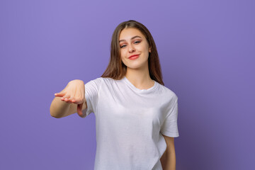 Fototapeta premium disaffected young brunette woman, looking clueless and upset with something, standing in blank white t shirt over purple background