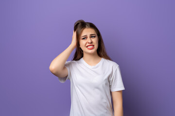 Fototapeta na wymiar Young brunette girl wearing casual white tshirt surprised with hand on head for mistake, remember error, forgot, bad memory concept