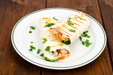 Thin lavash with vegetables and chicken on plate, shawarma. Studio Photo