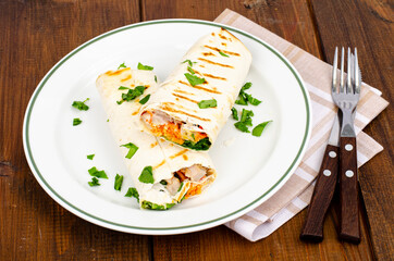 Thin lavash with vegetables and chicken on plate, shawarma. Studio Photo