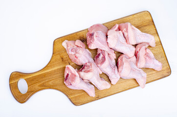 Raw chicken wings with bone and skin on wooden cutting board. Studio Photo