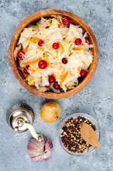 Sauerkraut with red cranberries in wooden bowl. Studio Photo