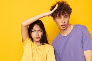 Fototapeta premium cute young couple in colorful t-shirts posing friendship fun yellow background unaltered