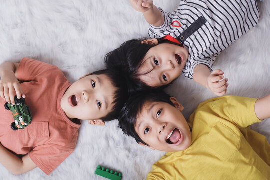 Close up top view of happy children showing their toys on white background