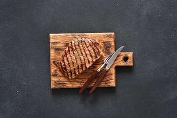 Beef steak medium re. Grilled meat with spices on a wooden board. View from above.
