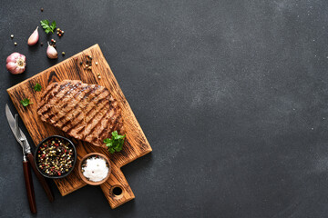 Beef steak medium re. Grilled meat with spices on a wooden board. View from above.