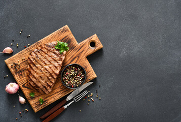 Beef steak medium re. Grilled meat with spices on a wooden board. View from above.