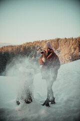 Fototapeta na wymiar A girl's walk in a snowy winter forest, playing with snow