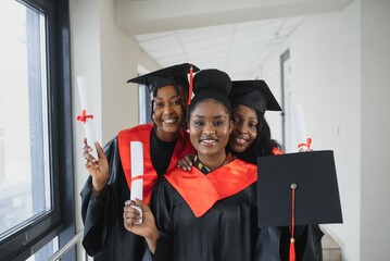 portrait of multiracial graduates holding diploma