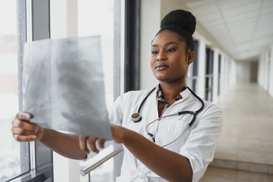 healt and medicine concept - smiling female doctor studying x-ray