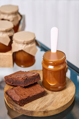 chocolate brownie with homemade caramel in a jar with a white spoon