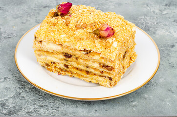 Piece of homemade puff pastry cake with cream on white plate. Studio Photo