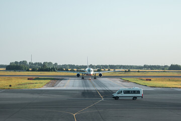 Transfer from the airport. White minibus is waiting for guests in front of the plane. High service, reception of guests.