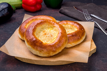Uzbek bread from tandoor on the board on dark table