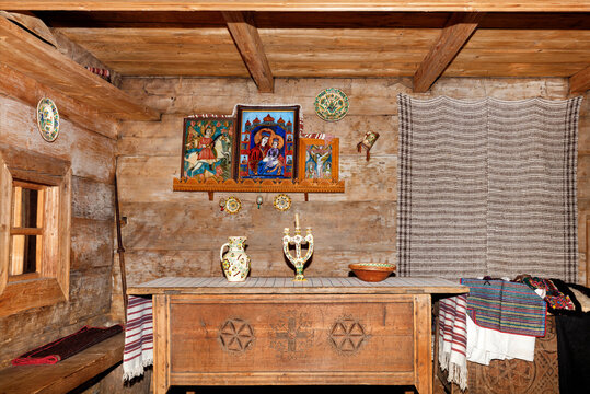 The interior of the living room of an old Ukrainian rural hut with holy images over a carved dining table and embroidered linen towels. 10.09.2021. Kyiv. Ukraine