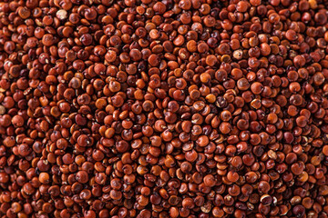 Organic red quinoa in a bowl on wooden table background.