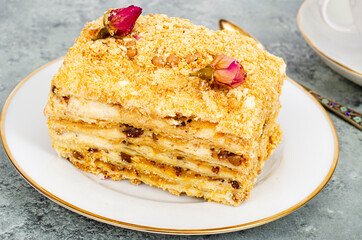 Piece of homemade puff pastry cake with cream on white plate. Studio Photo