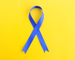 Blue ribbon on Yellow background prostate cancer awareness concept