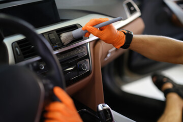 Hands brush dust from the ventilation system in the car