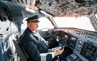 Side view. A professional pilot is in the cockpit. Conception of work © standret