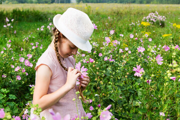Fototapeta premium Girl on the meadow with flowers.