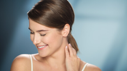 Female Beauty Portrait. Smiling Caucasian Woman with Brown Hair Embarrassed, Posing, Touching Her Authentic, Healthy Skin. Wellness and Skincare Concept on Soft Isolated Background. Close Up.