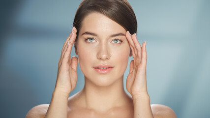 Female Beauty Portrait. Happy Caucasian Woman with Brown Hair and Light Green Eyes Posing, Touching Her Natural, Healthy Skin. Wellness and Skincare Concept on Soft Isolated Background. Close Up.