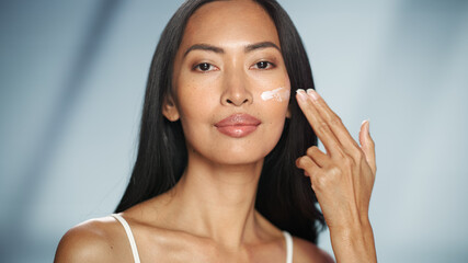 Female Beauty Portrait. Beautiful Smiling Asian Woman Touching Natural, Healthy Skin, Using...