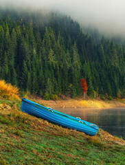 Blue boat near mountain lake during the autumn morning with fog	 - 480162365