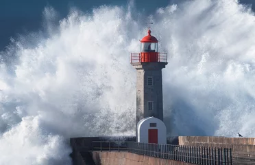Fototapeten lighthouse on the coast during storm - wave crashing © Eduardo