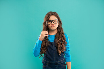 serious funny teen girl has curly hair hold party accessory of glasses, party time