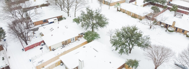 Panoramic top view heavy snow covered suburban houses roofs and cars at residential street near...
