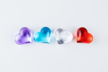 Translucent hearts - purple, blue, colorless and red on white background, four objects in row. Valentine's day symbol