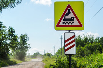 The road sign of the railway crossing. Attention motorists. Warning sign before the railway crossing.