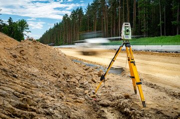 Surveyors equipment (theodolite or total positioning station) on the construction site of the road...