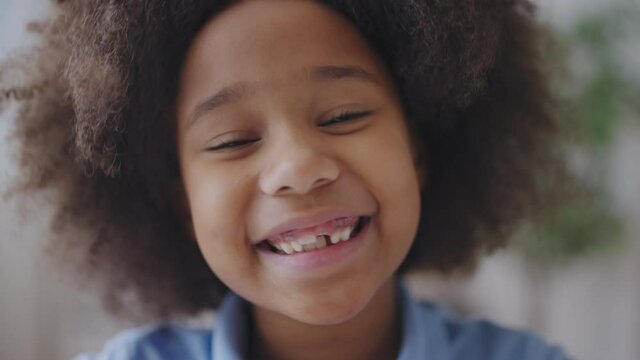 Smiling black girl showing missing tooth, dental care for children, tooth fairy