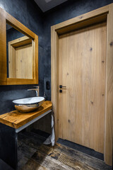 Stylish dark bathroom interior with shower. Tiles imitating wood on the floor and on the wall - 480168778