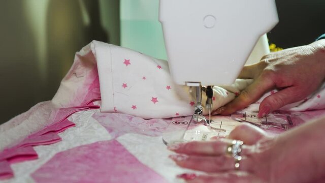 Stitching a pattern on a handmade quilt with a sewing machine fitted with a plastic template